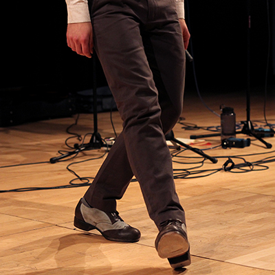 Tap dancing, cropped from waist down to show legs and shoes only on stage.